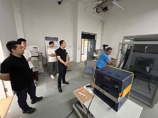 A group of men standing in a room

Description automatically generated